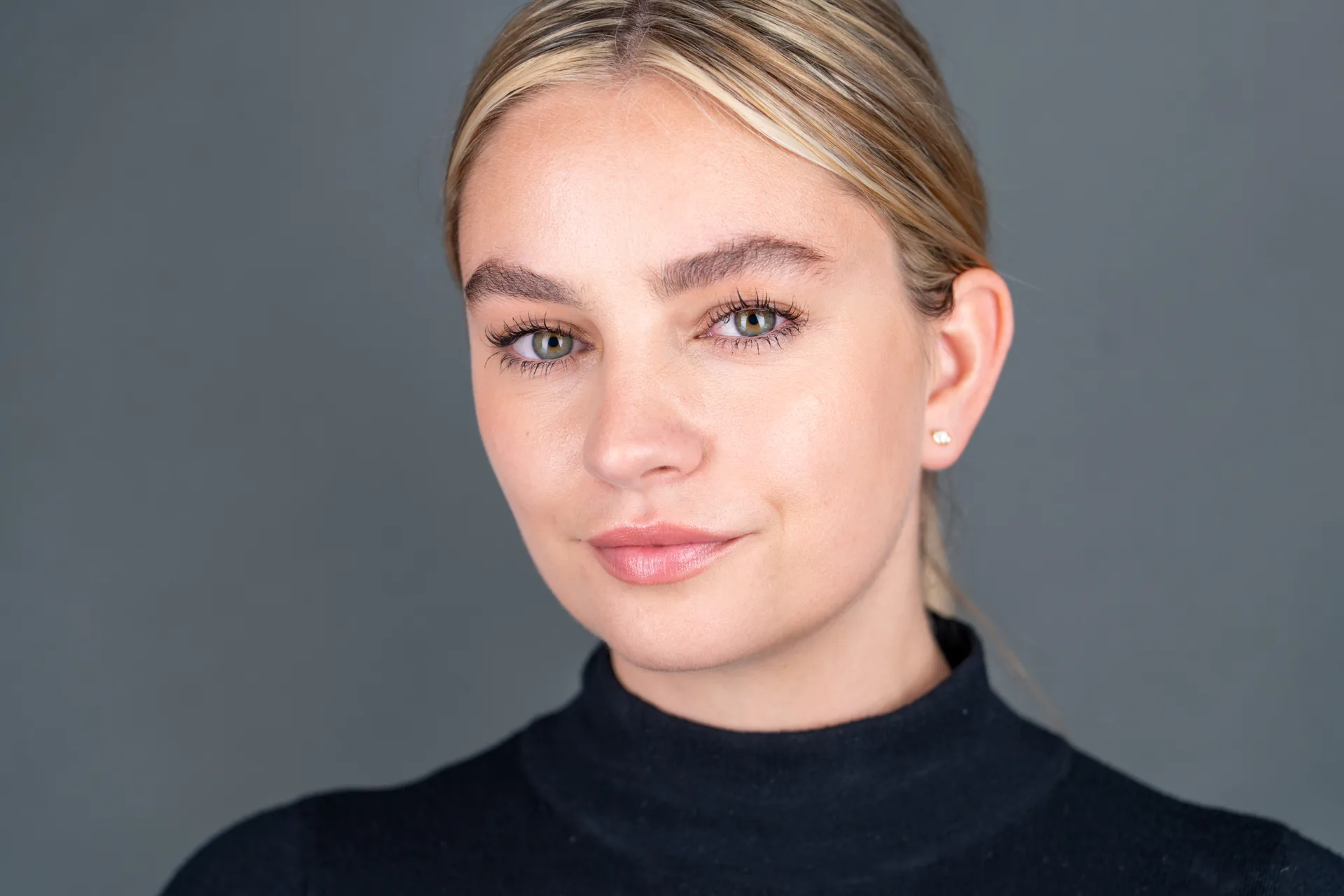 Studio style actor headshot of a woman on a grey background