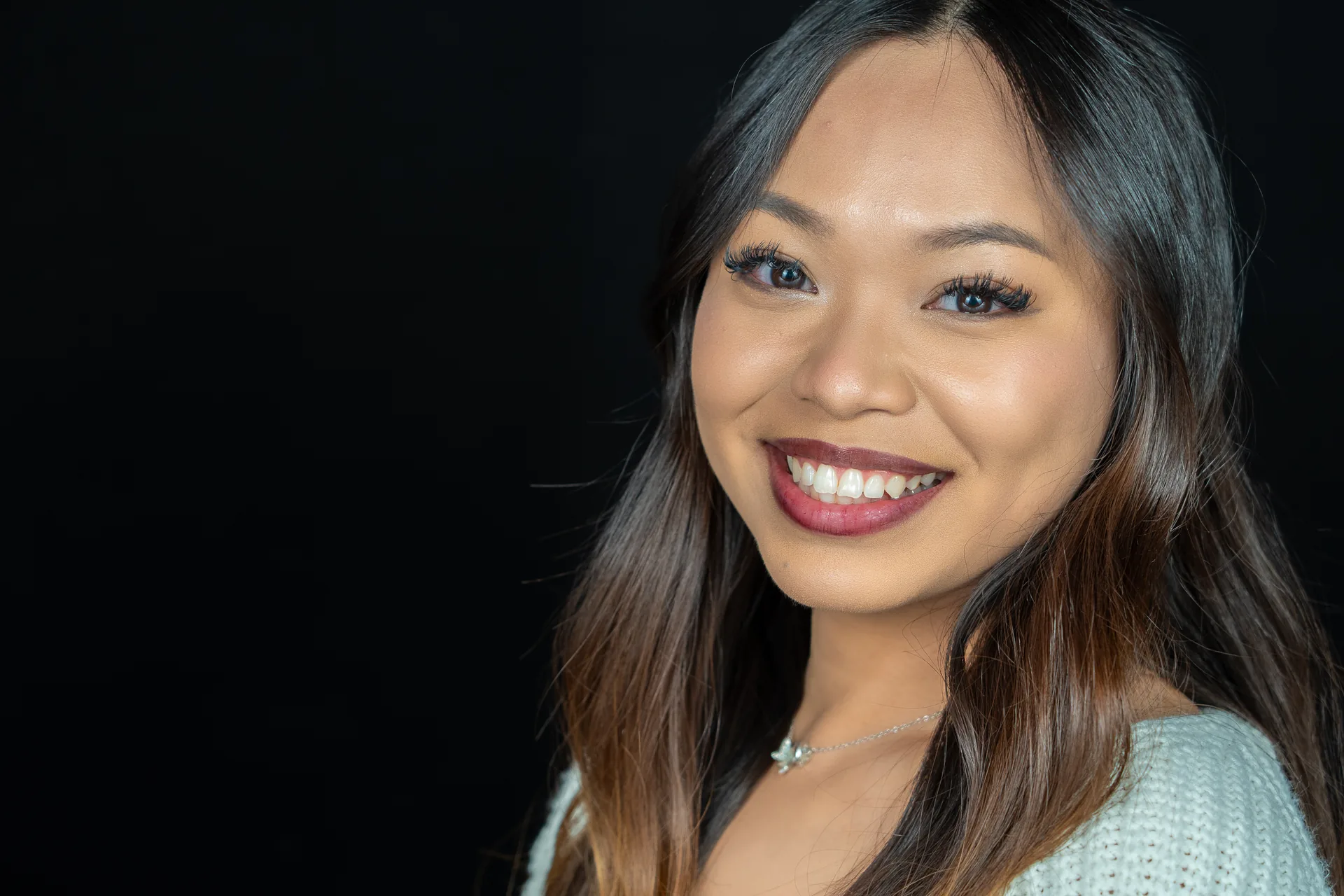 Smiling headshot of a woman against a teal background