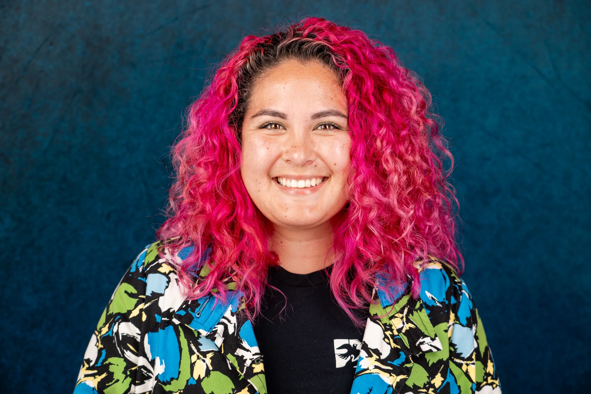Colorful actor headshot of a woman with curly red hair